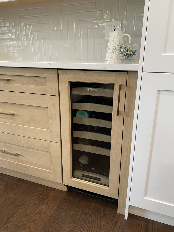 Example of a mid-sized transitional l-shaped medium tone wood floor and brown floor eat-in kitchen design in Toronto with an undermount sink, shaker cabinets, white cabinets, quartz countertops, white backsplash, quartz backsplash, stainless steel appliances, an island and white countertops