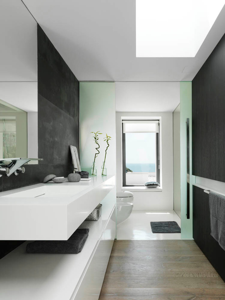 Design ideas for a mid-sized contemporary 3/4 bathroom in Barcelona with a trough sink, flat-panel cabinets, white cabinets, black tile and black walls.