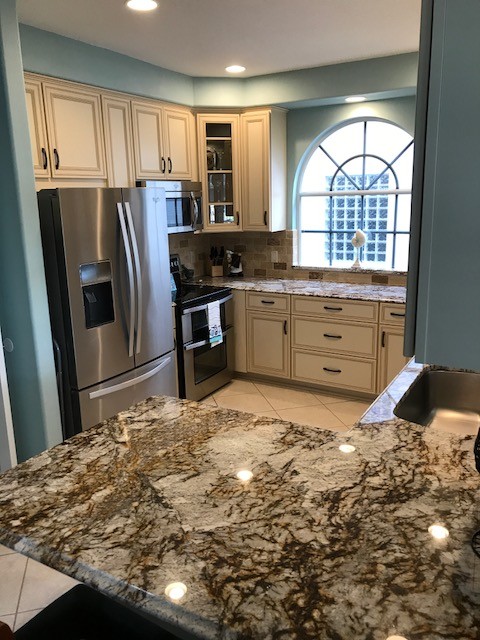 Design ideas for a mid-sized traditional u-shaped eat-in kitchen in Tampa with granite benchtops and travertine splashback.