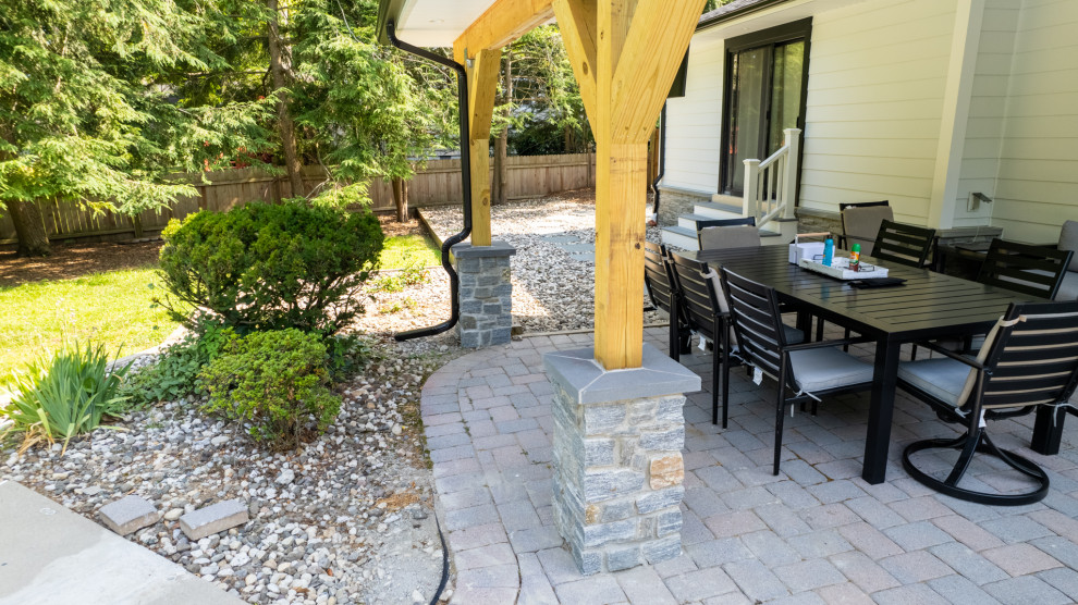 На фото: маленький двор на заднем дворе в современном стиле с мощением тротуарной плиткой и навесом для на участке и в саду