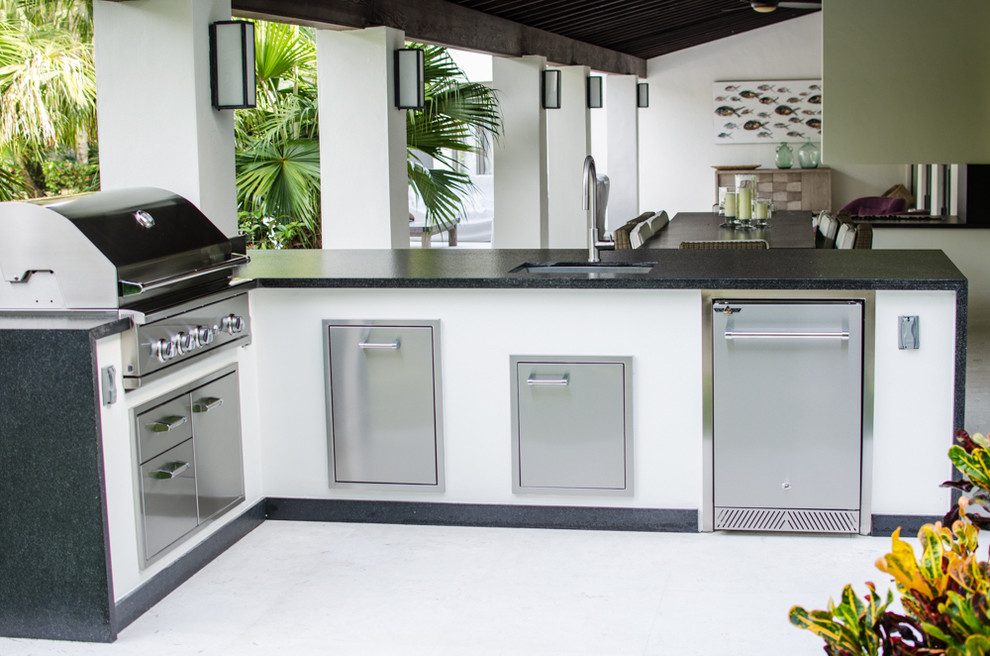 This is an example of a mid-sized contemporary backyard patio in Miami with an outdoor kitchen.
