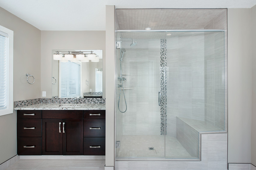Example of a large transitional master gray tile and porcelain tile porcelain tile freestanding bathtub design in Calgary with an undermount sink, granite countertops, dark wood cabinets and beige walls