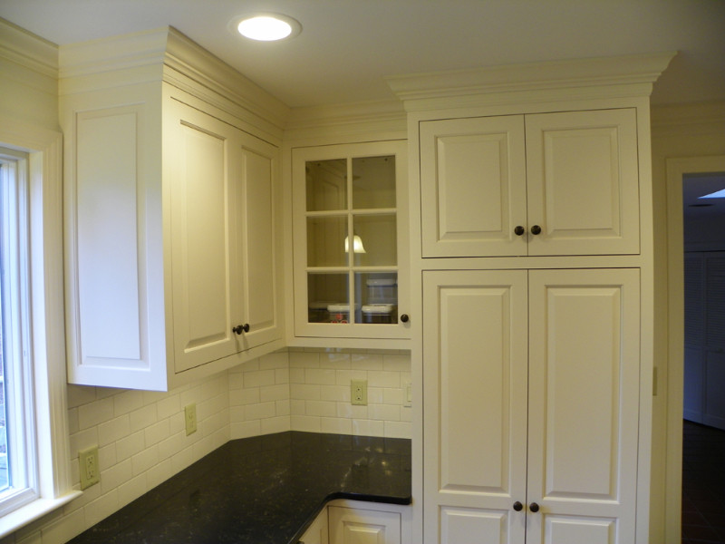 Mid-sized transitional u-shaped light wood floor eat-in kitchen photo in Boston with an undermount sink, beaded inset cabinets, white cabinets, quartz countertops, white backsplash, subway tile backsplash, stainless steel appliances and no island