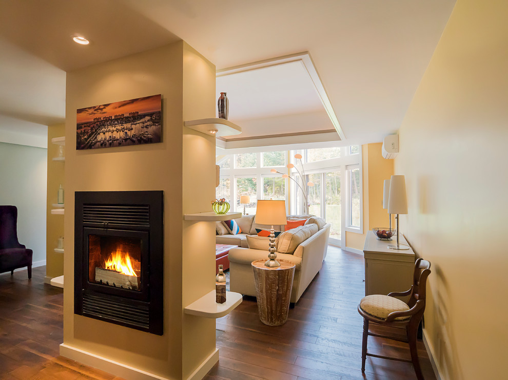 Photo of a large transitional formal open concept living room in Burlington with yellow walls, dark hardwood floors, a plaster fireplace surround, a freestanding tv and a two-sided fireplace.