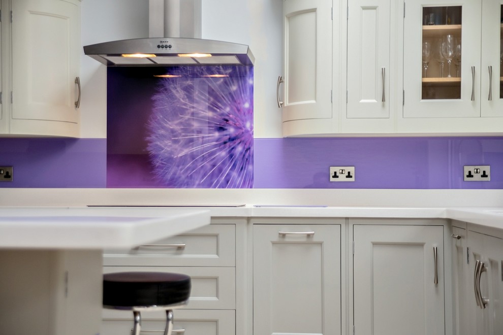 This is an example of a modern kitchen in Hertfordshire with glass sheet splashback.