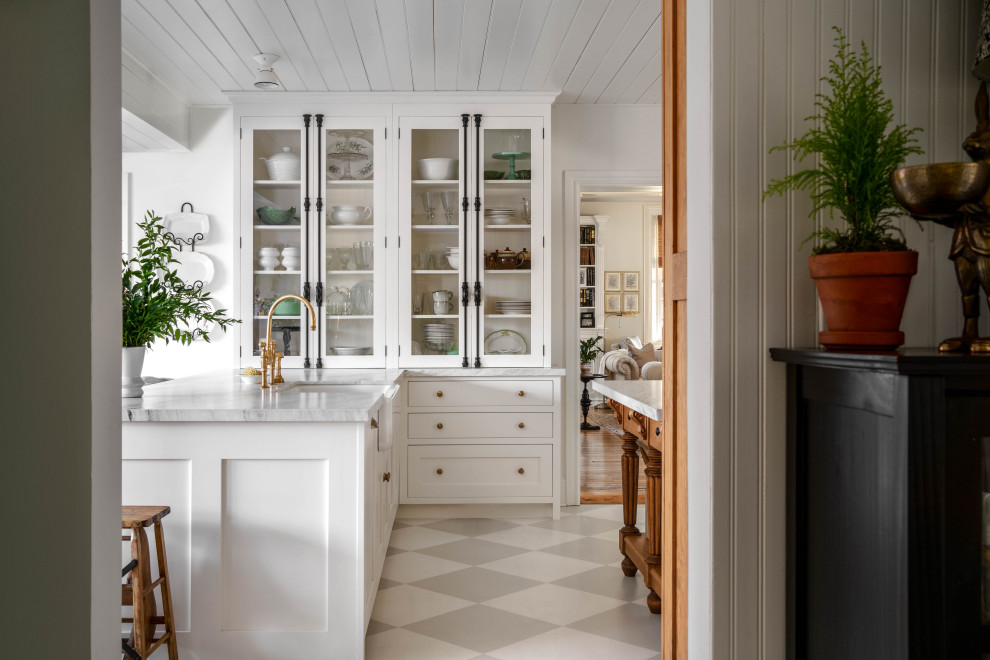 Inspiration for a mid-sized u-shaped eat-in kitchen in Toronto with a farmhouse sink, recessed-panel cabinets, white cabinets, marble benchtops, white splashback, subway tile splashback, panelled appliances, light hardwood floors, multiple islands, grey floor, white benchtop and timber.