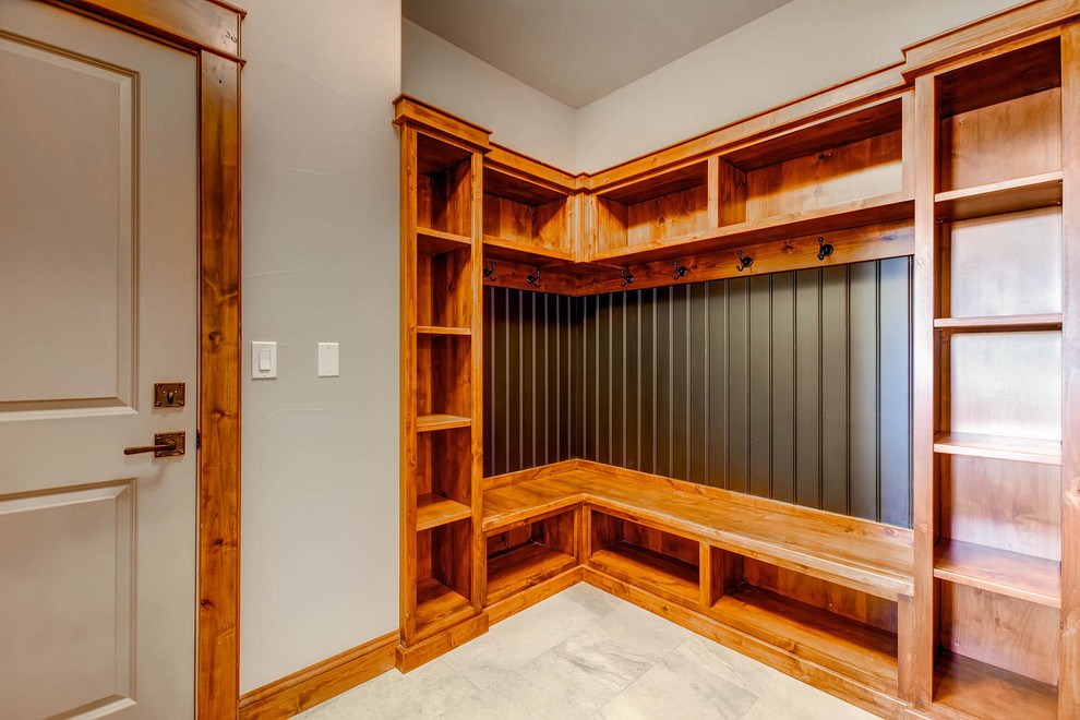 This is an example of an arts and crafts mudroom in Denver with beige walls and beige floor.