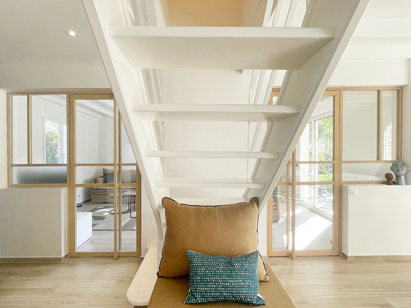 Идея дизайна: изогнутая лестница среднего размера в скандинавском стиле с крашенными деревянными ступенями, металлическими перилами и кладовкой или шкафом под ней без подступенок