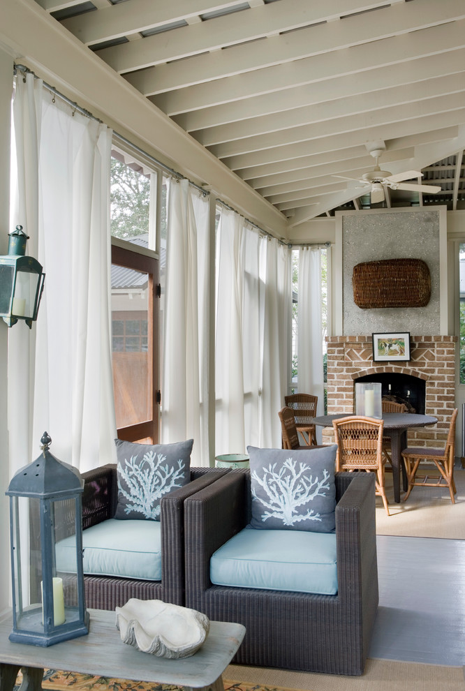This is an example of a beach style verandah in Atlanta with a fire feature and a roof extension.