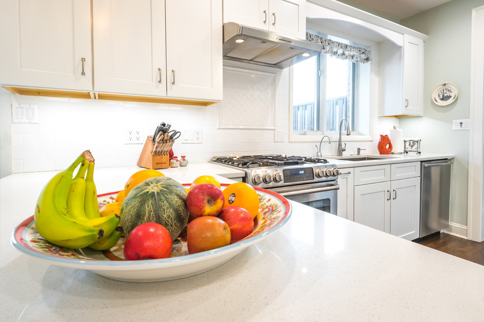 Inspiration for a mid-sized transitional galley dark wood floor enclosed kitchen remodel in Chicago with an undermount sink, recessed-panel cabinets, white cabinets, quartz countertops, white backsplash, subway tile backsplash, stainless steel appliances and no island