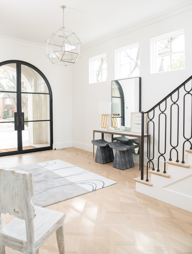 Photo of a transitional foyer in Dallas with white walls, light hardwood floors, a double front door, a glass front door and beige floor.