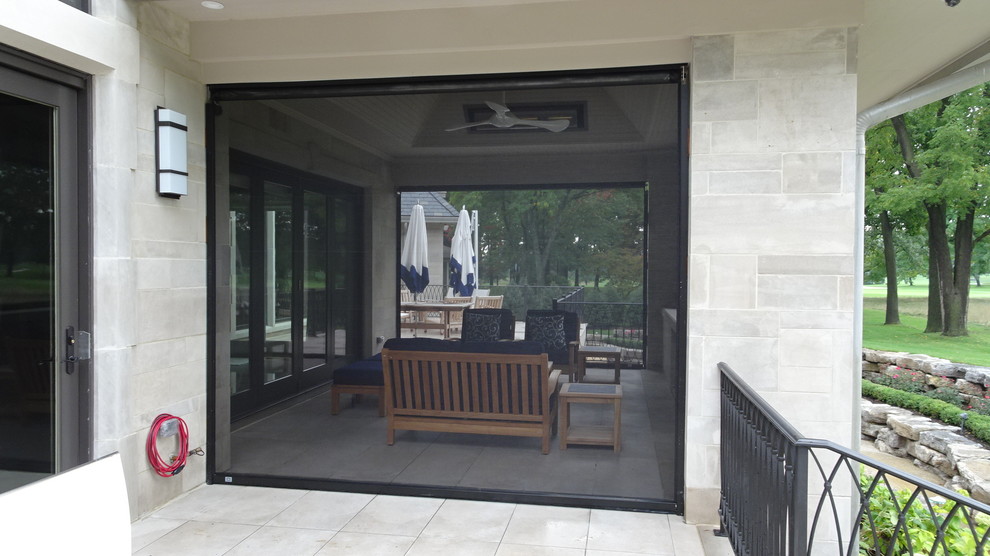 Inspiration for a mid-sized modern backyard screened-in verandah in Detroit with a roof extension and natural stone pavers.