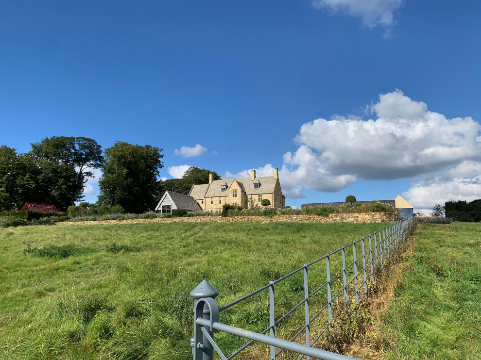 Großes, Dreistöckiges Country Einfamilienhaus mit Steinfassade, brauner Fassadenfarbe, Satteldach, Ziegeldach und braunem Dach in Oxfordshire