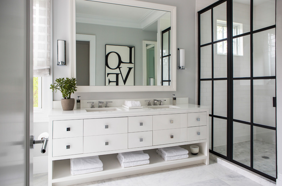 Inspiration for a transitional master bathroom in New York with flat-panel cabinets, white cabinets, an alcove shower, white tile, subway tile, grey walls, an undermount sink, white floor, a sliding shower screen and white benchtops.