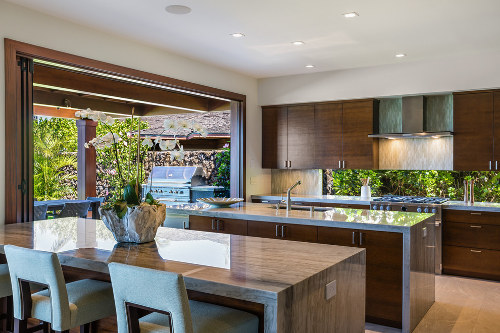 This is an example of a tropical kitchen in Other with an undermount sink, flat-panel cabinets, dark wood cabinets, beige splashback, stainless steel appliances, multiple islands and beige floor.