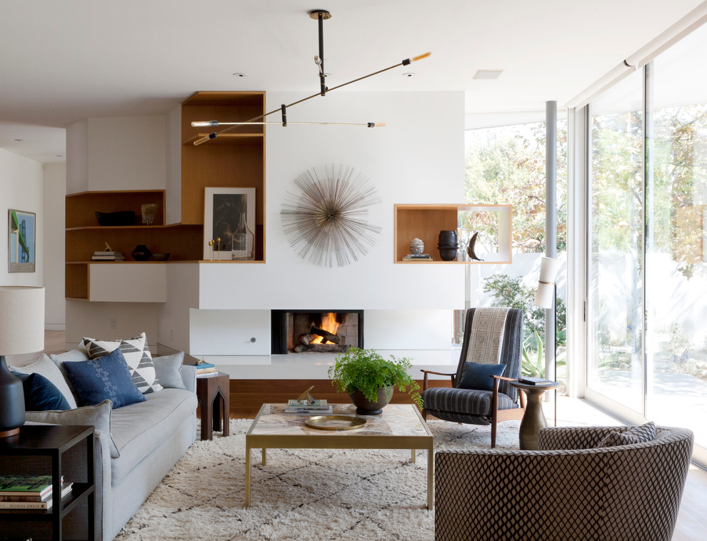 Photo of a modern living room in Los Angeles with white walls and a standard fireplace.