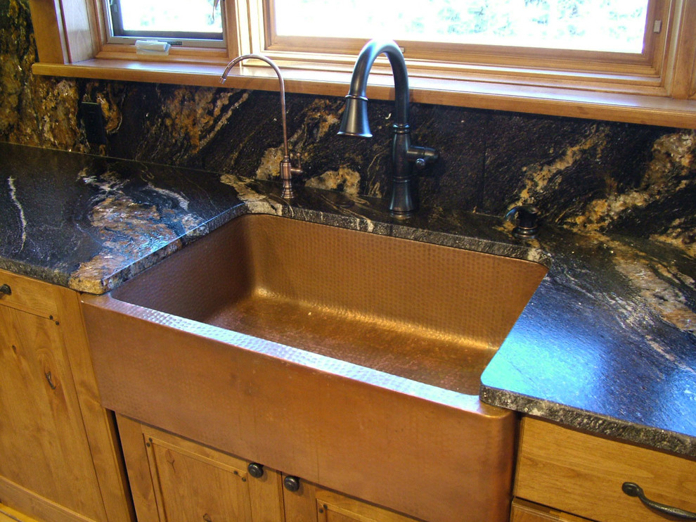 Mid-sized mountain style u-shaped light wood floor kitchen pantry photo in Denver with a farmhouse sink, flat-panel cabinets, dark wood cabinets, granite countertops, black backsplash, stone slab backsplash, stainless steel appliances and no island