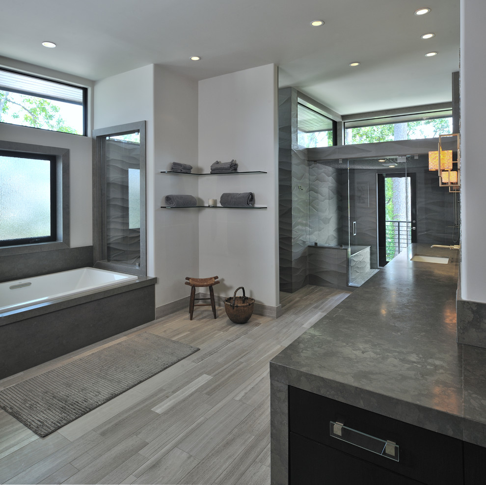 Inspiration for a contemporary bathroom in Houston with a drop-in tub, an alcove shower, gray tile and grey floor.