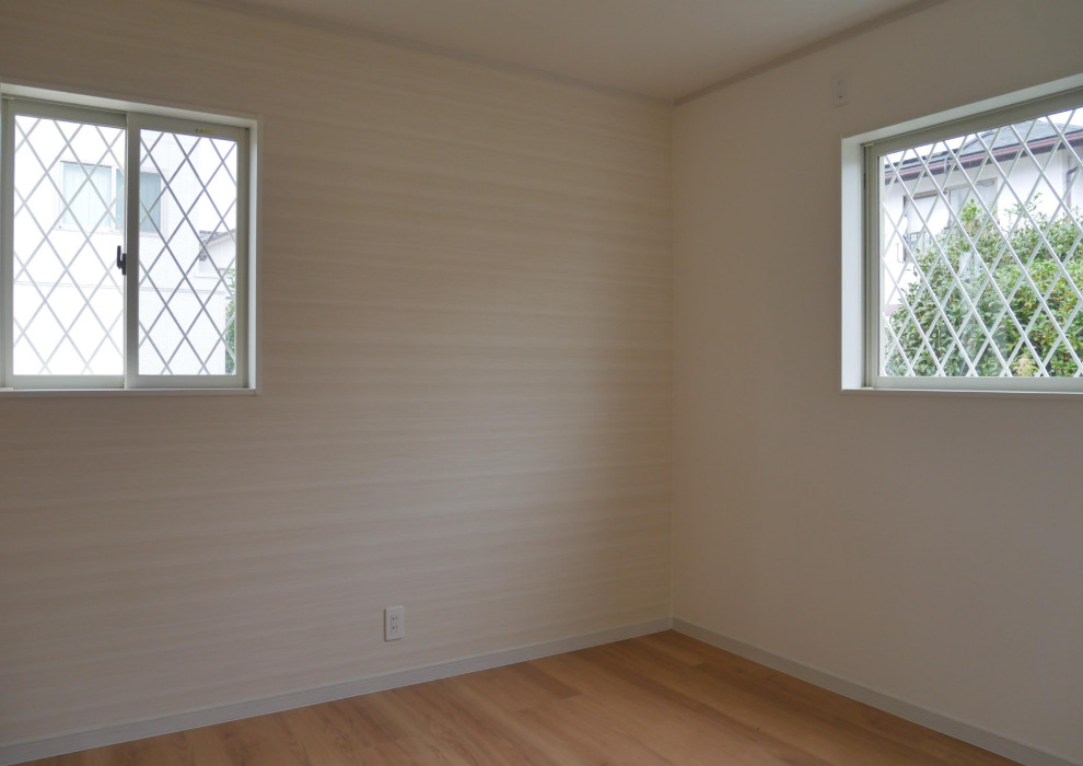 Modern inredning av ett mellanstort huvudsovrum, med beige väggar, plywoodgolv och brunt golv