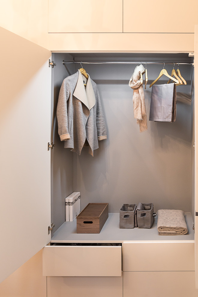 This is an example of a mid-sized contemporary women's built-in wardrobe in Paris with flat-panel cabinets and white cabinets.