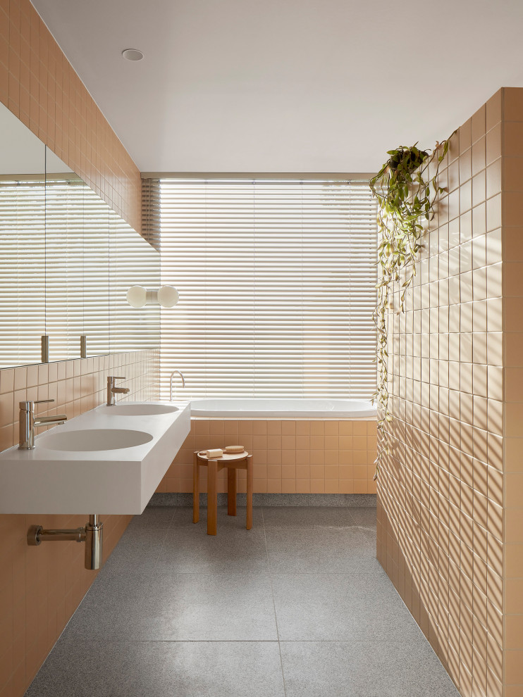 На фото: детская ванная комната среднего размера в стиле модернизм с белыми фасадами, накладной ванной, душем в нише, оранжевой плиткой, серым полом, открытым душем, белой столешницей, тумбой под две раковины и подвесной тумбой