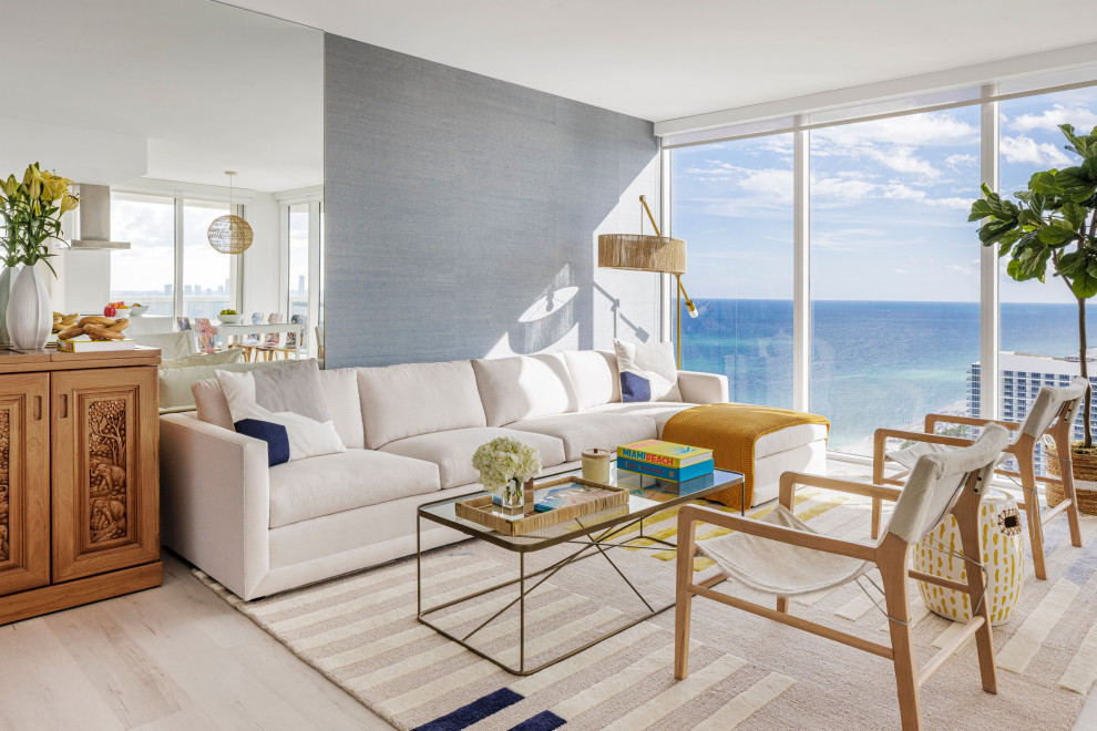 Photo of a mid-sized beach style formal open concept living room in Miami with white walls, light hardwood floors and wallpaper.