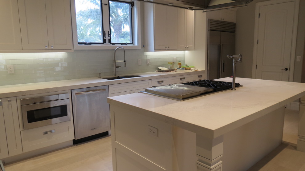 Inspiration for a large transitional l-shaped light wood floor and beige floor enclosed kitchen remodel with a double-bowl sink, shaker cabinets, white cabinets, marble countertops, blue backsplash, glass tile backsplash, stainless steel appliances and an island