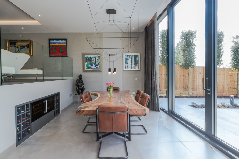 Design ideas for a mid-sized contemporary open plan dining in Surrey with grey walls, no fireplace and grey floor.
