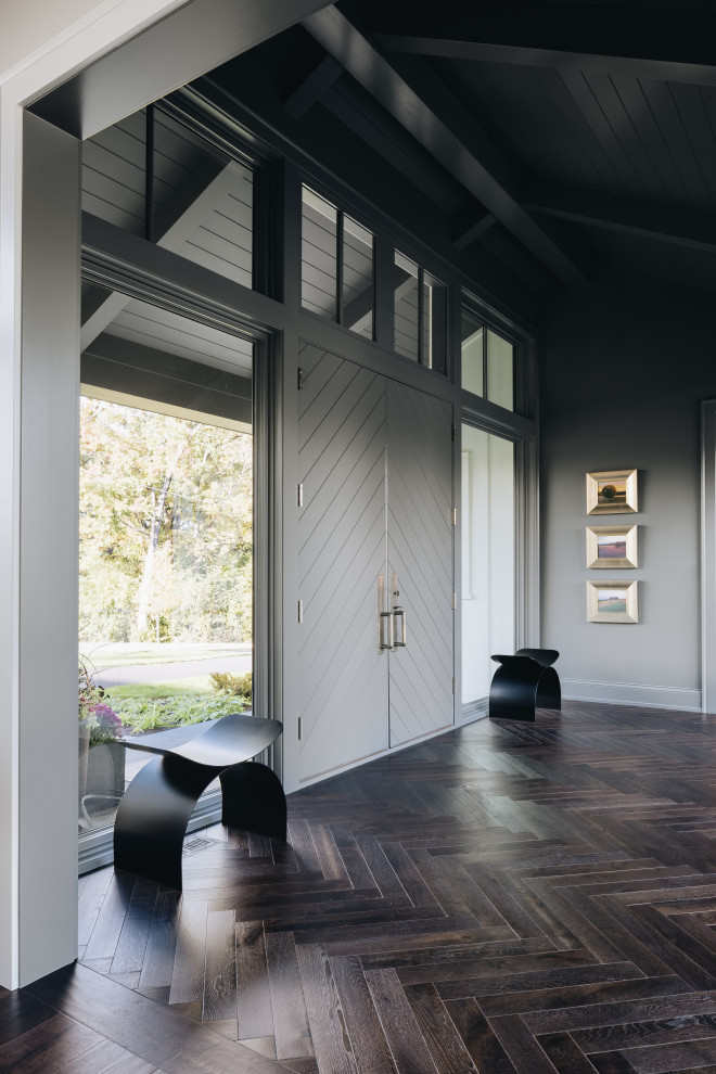 Источник вдохновения для домашнего уюта: большая входная дверь в стиле неоклассика (современная классика) с серыми стенами, темным паркетным полом, двустворчатой входной дверью, серой входной дверью, коричневым полом и сводчатым потолком