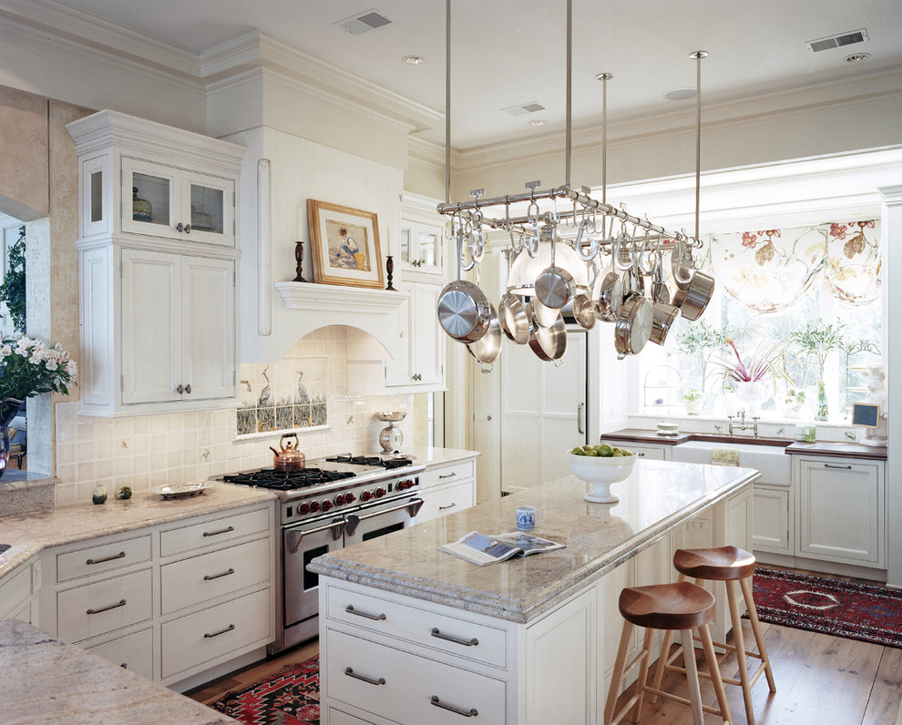 Design ideas for a large traditional u-shaped open plan kitchen in Atlanta with beaded inset cabinets, a farmhouse sink, white cabinets, granite benchtops, white splashback, stainless steel appliances, light hardwood floors and with island.