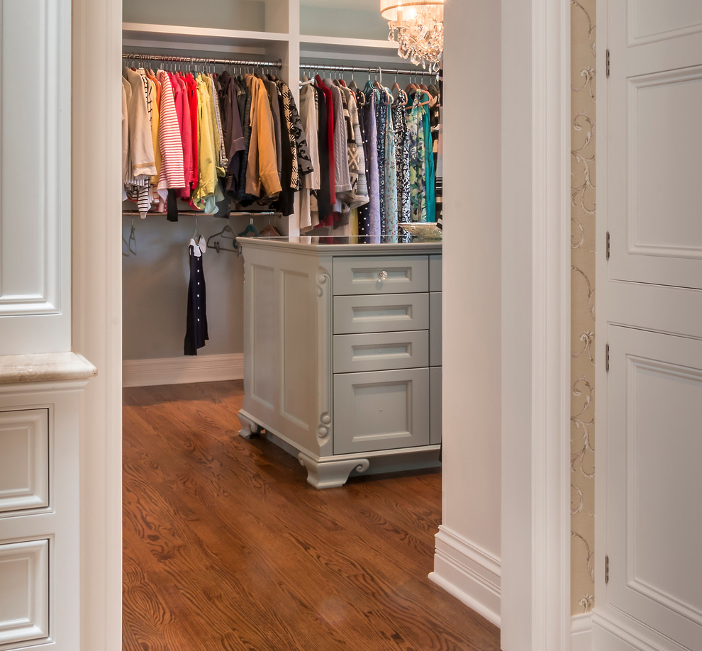 Inspiration for a large traditional women's dressing room in Chicago with green cabinets, open cabinets and medium hardwood floors.