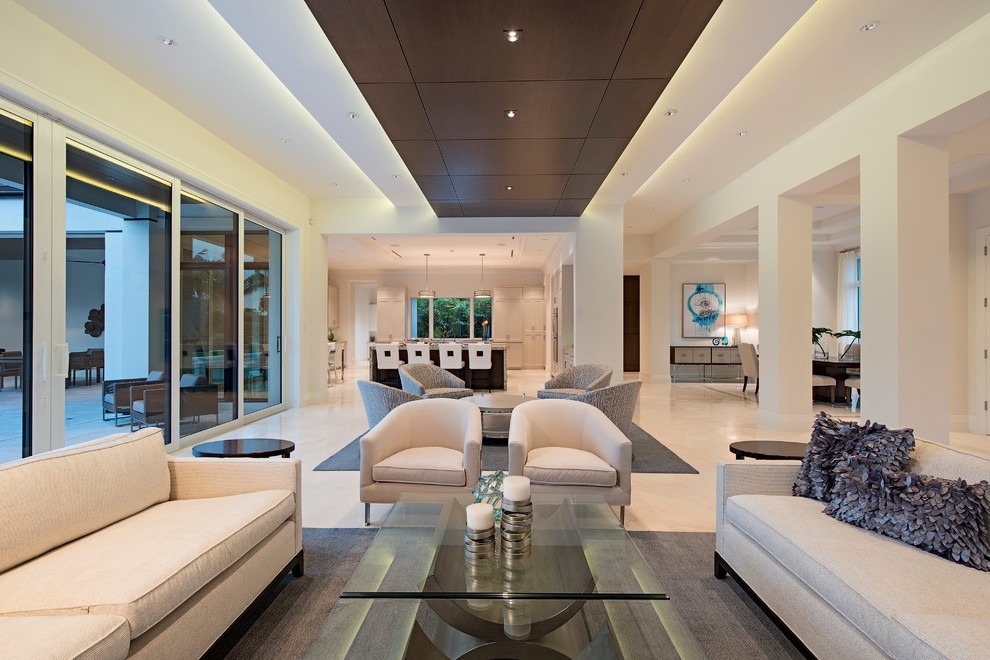 Photo of a large transitional open concept living room in Miami with marble floors, a standard fireplace, a stone fireplace surround and white walls.