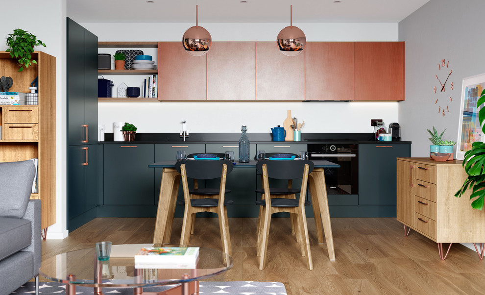 This is an example of a small contemporary l-shaped open plan kitchen in Other with flat-panel cabinets, blue cabinets, black appliances, light hardwood floors, no island, brown floor and black benchtop.