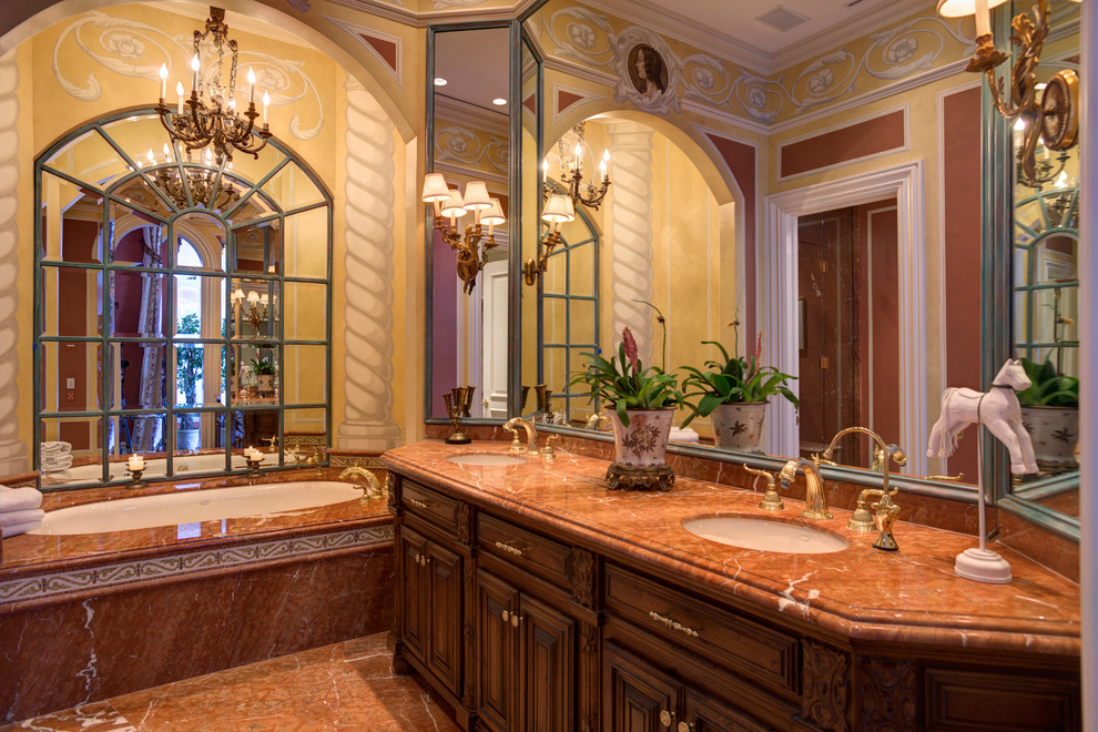 Design ideas for a large mediterranean master bathroom in New York with raised-panel cabinets, medium wood cabinets, a hot tub, an open shower, a two-piece toilet, porcelain tile, red walls, marble floors, a drop-in sink, marble benchtops and brown tile.
