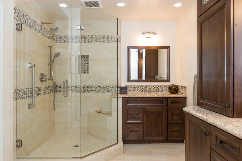 Large transitional master beige tile and porcelain tile porcelain tile corner shower photo in Orange County with recessed-panel cabinets, dark wood cabinets, white walls, an undermount sink and granite countertops