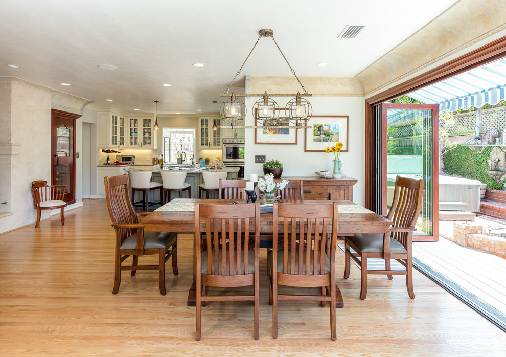 Large transitional open plan dining in Los Angeles with beige walls, light hardwood floors and no fireplace.