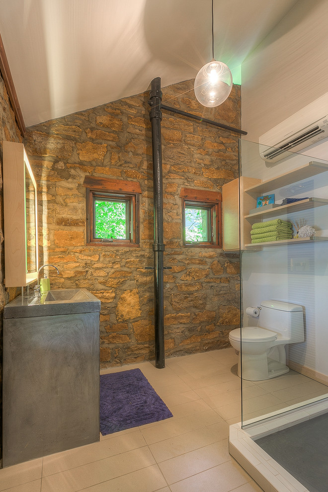 This is an example of a small modern 3/4 bathroom in Kansas City with a trough sink, concrete benchtops, a double shower, a one-piece toilet, flat-panel cabinets, light wood cabinets, white tile, subway tile, white walls and porcelain floors.