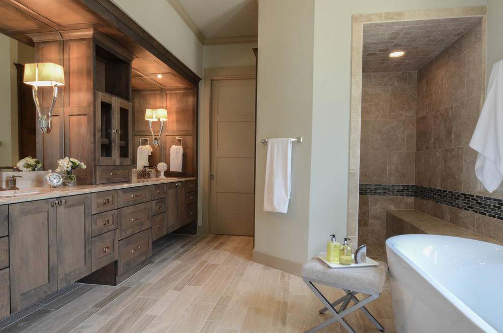 Photo of a large contemporary master bathroom in Austin with an undermount sink, shaker cabinets, medium wood cabinets, marble benchtops, a freestanding tub, an open shower, a one-piece toilet, beige tile, stone tile, green walls and travertine floors.