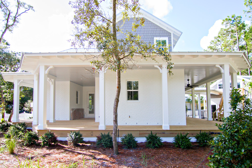 Large beach style two-storey brick white exterior in Jacksonville with a gable roof.