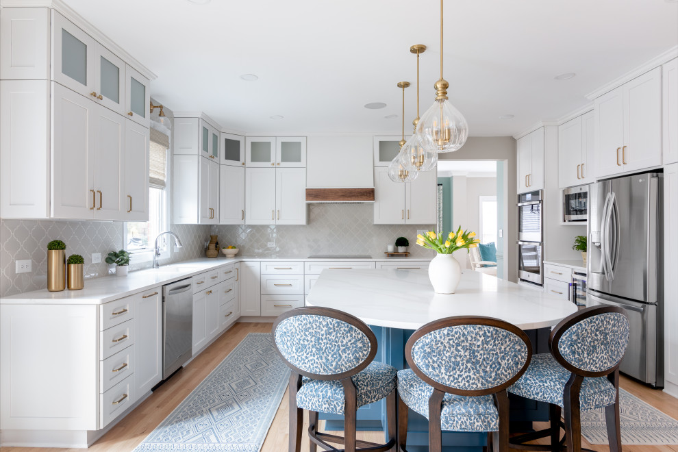 Eat-in kitchen - large transitional light wood floor and brown floor eat-in kitchen idea with a drop-in sink, shaker cabinets, quartz countertops, gray backsplash and an island