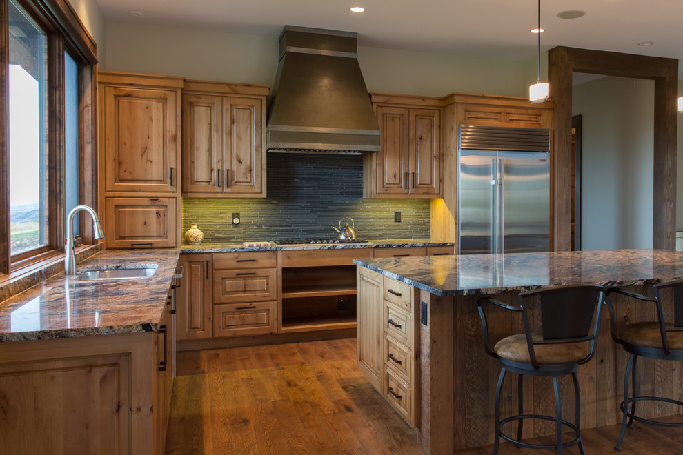Example of a transitional l-shaped light wood floor eat-in kitchen design with an island, a drop-in sink, flat-panel cabinets, medium tone wood cabinets, granite countertops, gray backsplash, stone tile backsplash and stainless steel appliances