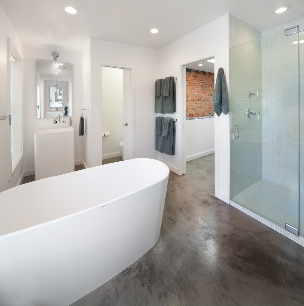 Design ideas for a large industrial master bathroom in DC Metro with a pedestal sink, a freestanding tub, an alcove shower, white tile, mosaic tile, concrete floors and an enclosed toilet.