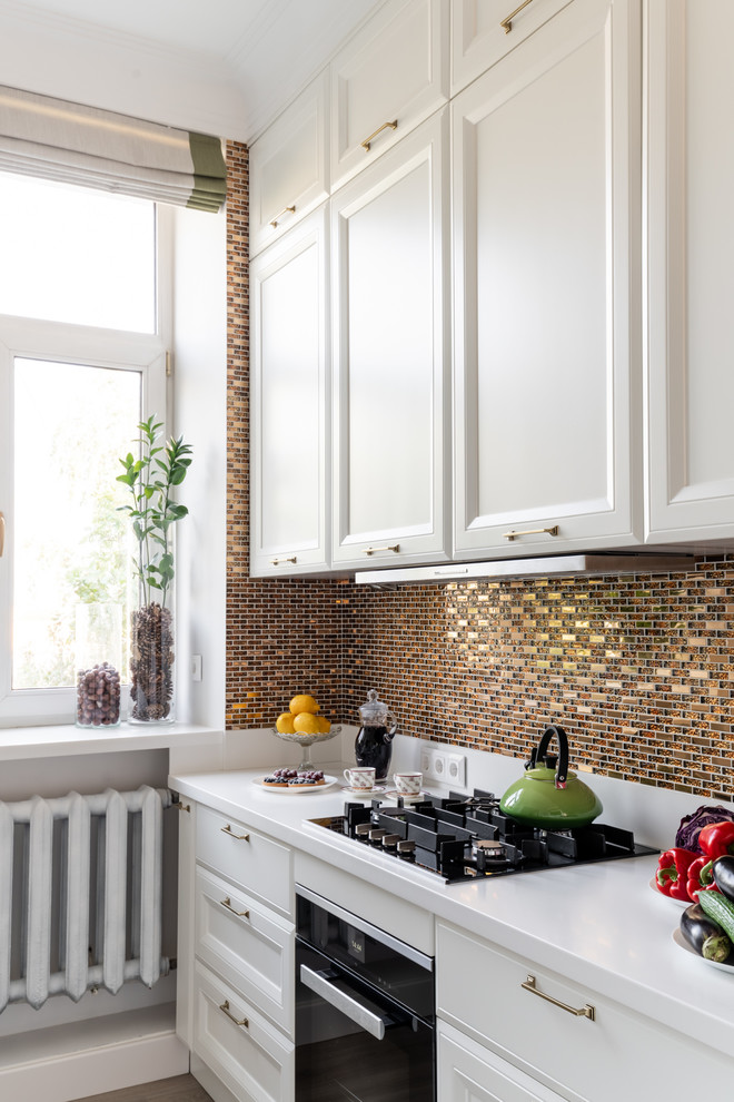 Inspiration for a mid-sized transitional l-shaped separate kitchen in Moscow with an undermount sink, raised-panel cabinets, white cabinets, solid surface benchtops, yellow splashback, mosaic tile splashback, stainless steel appliances, laminate floors, beige floor and white benchtop.