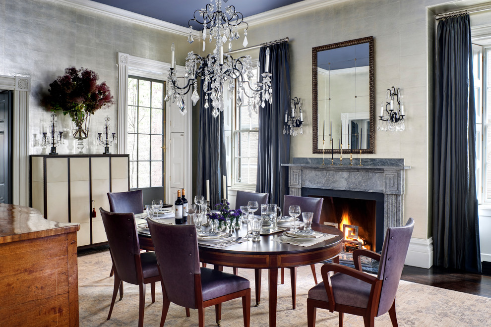 Photo of a traditional separate dining room in Boston with metallic walls, dark hardwood floors, a standard fireplace and brown floor.