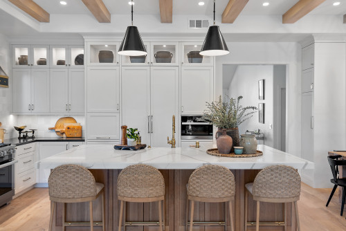 Modern kitchen with soft white cabinetry, wood-tone island base, and black pendant lights inspired by popular IKEA kitchen cabinet colors Canada 2026.