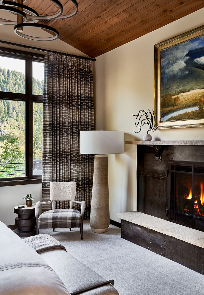 Design ideas for a mid-sized country master bedroom in Denver with beige walls, carpet, a standard fireplace, a metal fireplace surround and grey floor.