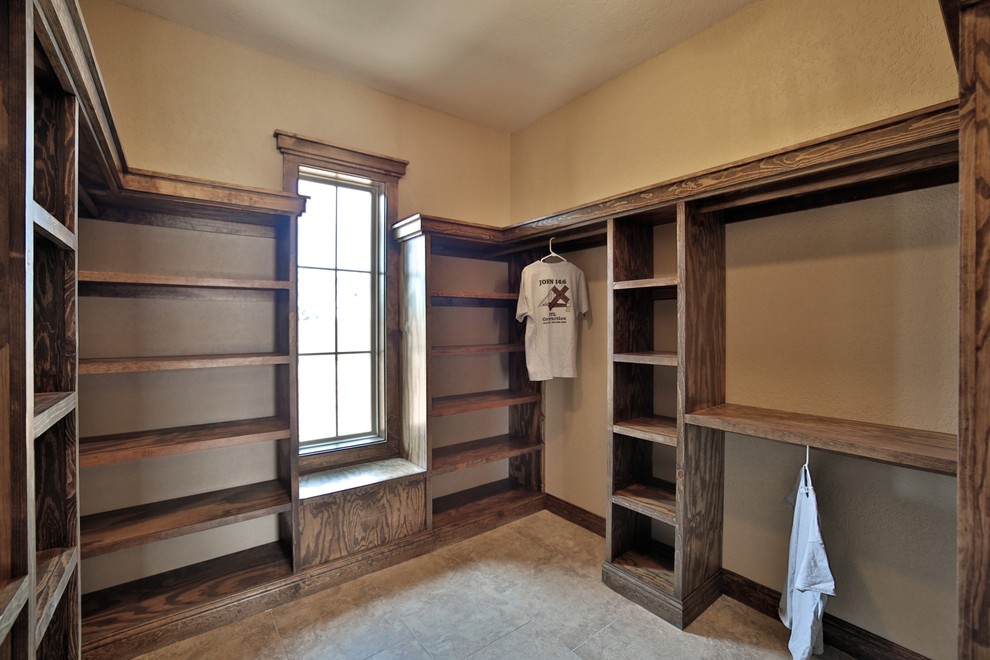 Mid-sized mediterranean gender-neutral walk-in wardrobe in Dallas with open cabinets, medium wood cabinets and porcelain floors.