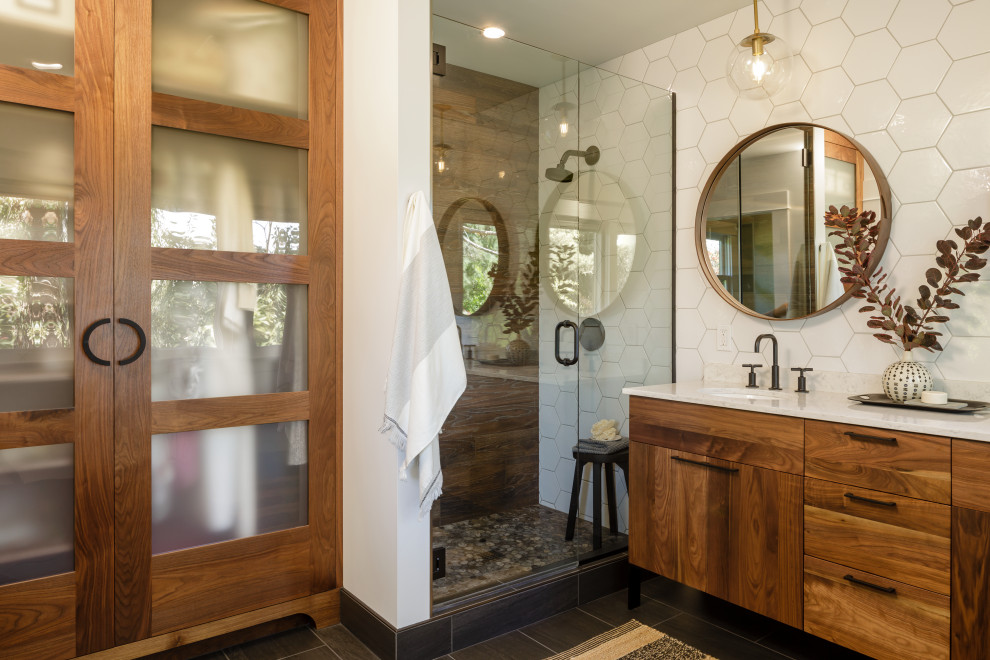 This is an example of a mid-sized midcentury bathroom in Portland with flat-panel cabinets, medium wood cabinets, an alcove shower, brown tile, white tile, wood-look tile, white walls, an undermount sink, grey floor, a hinged shower door, white benchtops and a freestanding vanity.