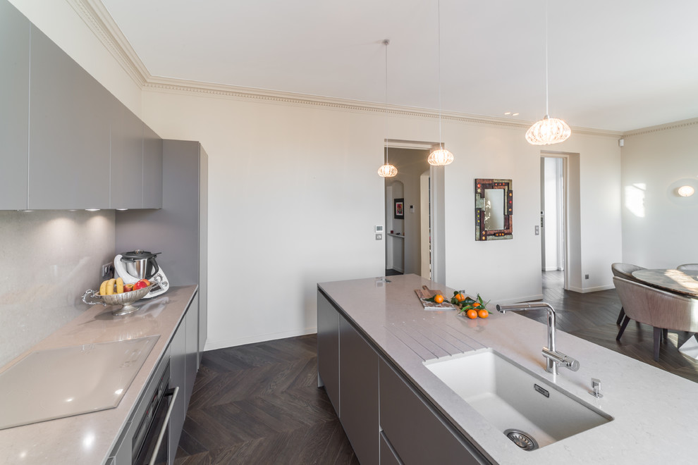 Design ideas for a large contemporary galley open plan kitchen in Nice with an undermount sink, grey cabinets, quartz benchtops, grey splashback, panelled appliances and with island.