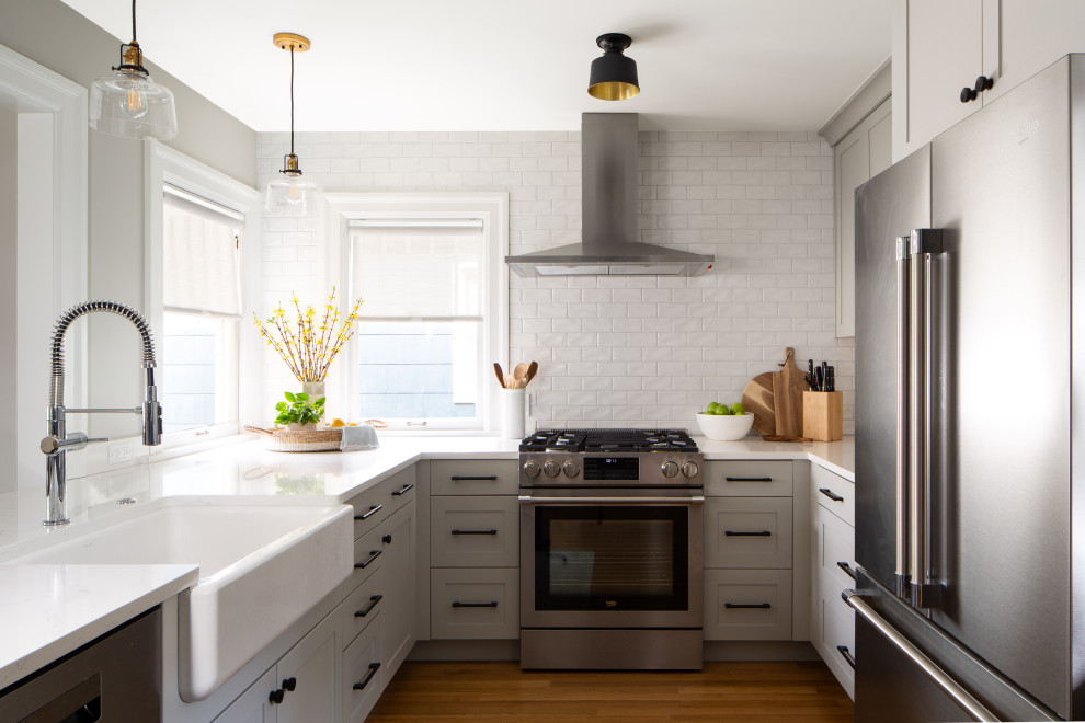Imagen de cocina clásica renovada con electrodomésticos de acero inoxidable, fregadero sobremueble, armarios con paneles empotrados y puertas de armario grises